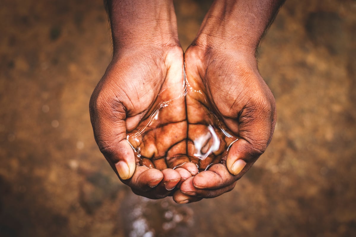 a man holding water in his hand,save water,water crisis in India and worldwide